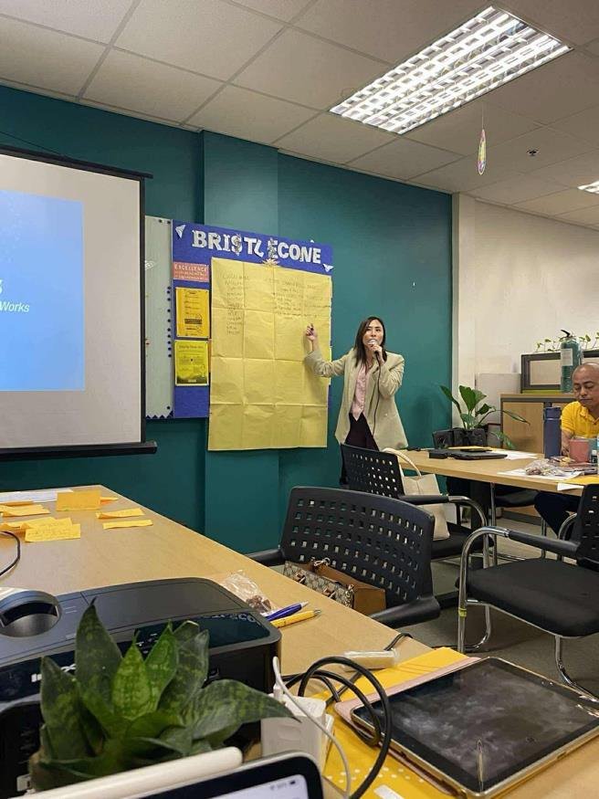 Weanne facilitating a strategic planning session in front of a sticky-note board